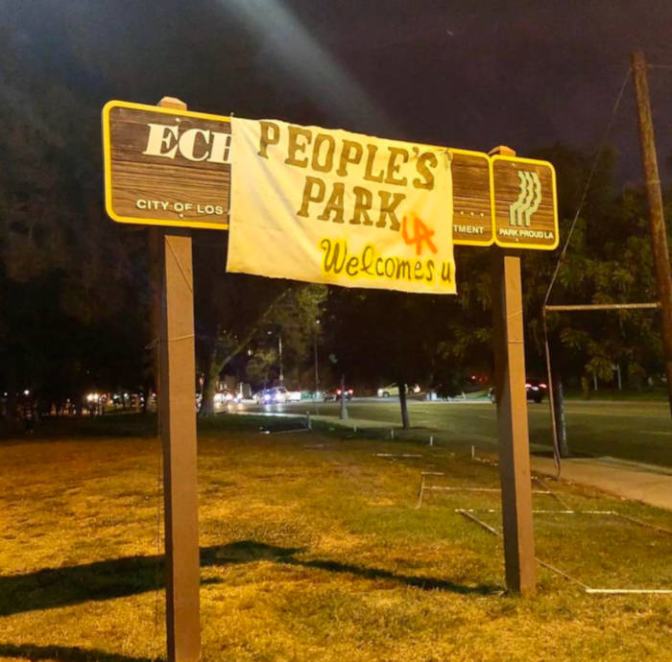 Park sign with handmade banner reading, 